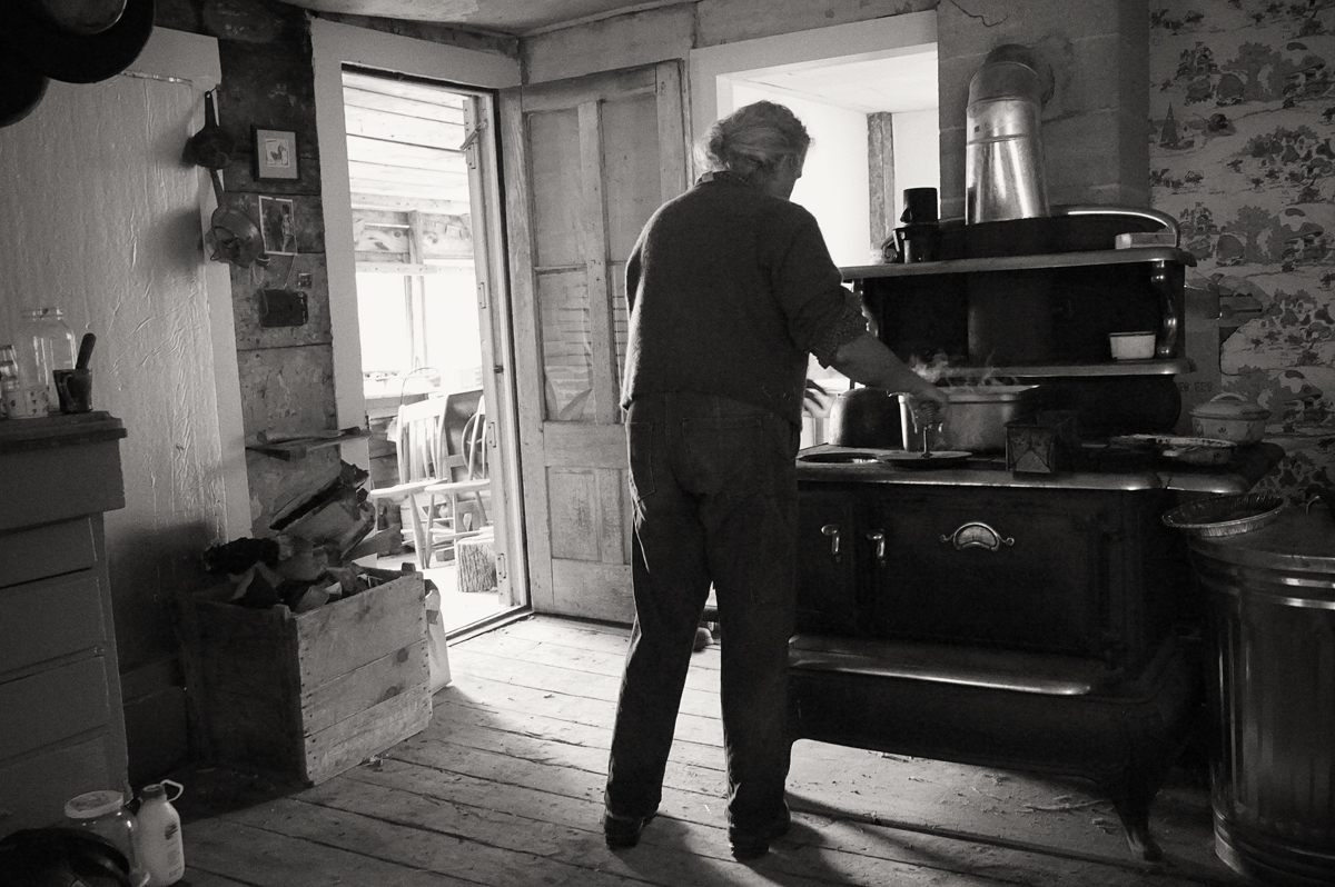 Environmental portrait, Vermont farm kitchen, wood cookstove, woman farmer cooking, old farm house, rural living, simple life, old fashioned, traditional