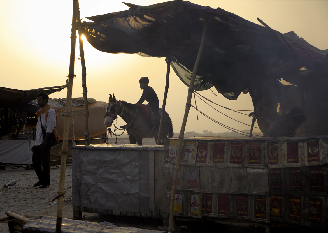 Street photography, boy on horse, river bank, sunrise, early morning, food preparation, food stall, plastic sheet, awning, Varanasi, Indi
