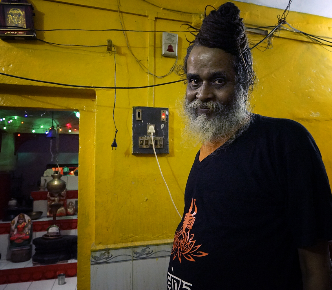 portrait, electric wiring, sadhu, at home, shrine, colored lights, Varanasi, India
